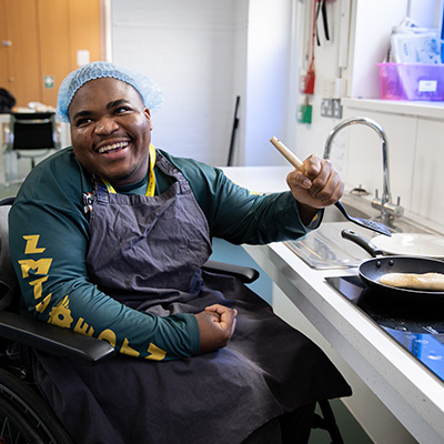 Student cooking in the independent living kitchen